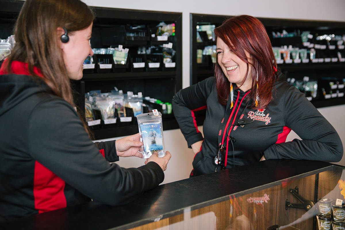 Remedy concierge Liss Smith and Jennifer Bontempo compare notes on one of the many cannabis strains available at the store. Photo by Genna Martin