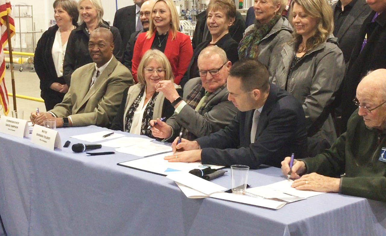 DOUGLAS BUELL/Staff Photo                                Marysville Mayor Jon Nehring signs an agreement to partner with Arlington and the Port of Everett to work together on making the Cascade Industrial Center a success. The event was hosted at Elemental Cider Co. in Arlington, one of the newest businesses within the 4000-acre CIC area near the municipal airport. Seated from left, Port Commissioner David Simpson, Arlington Mayor Barb Tolbert, Commissioner Glen Bachmann, Marysville Mayor Jon Nehring and Commissioner Tom Stiger.