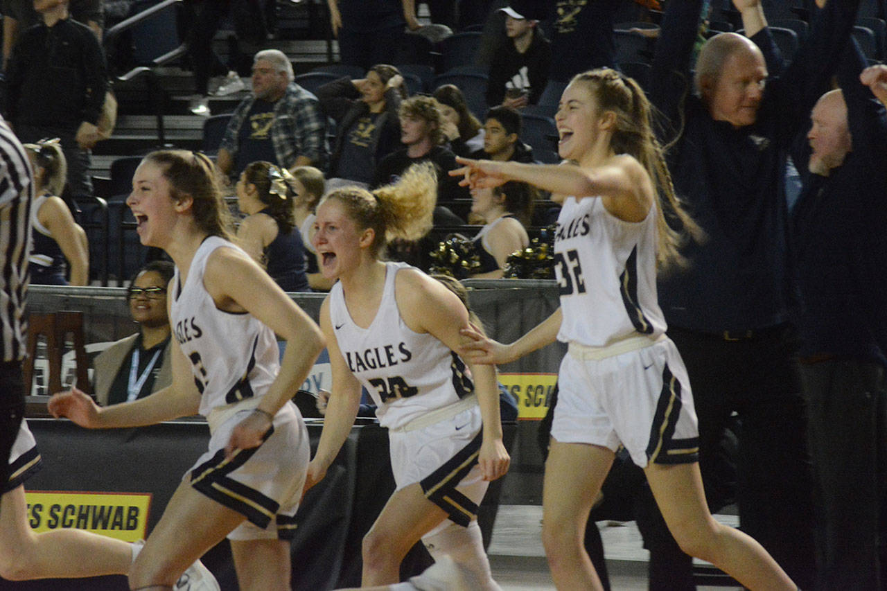 Players on the Arlington bench jump out of their seats and rush the court after the game ends.