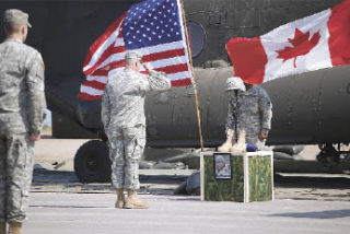 An unidentified soldier salutes a memorial to Specialist Joseph M. Cerfus during a service held last week. A Marysville resident and Army Reservist