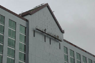 These construction workers are using exactly the type of wall climbing rig firefighters say could malfunction and necessitate a high altitude rescue.