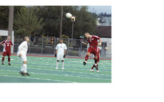 Senior midfielder Nick Burdett heads the ball in the Tomahawks’ state tournament opener against Puyallup. Burdett had the assist on M-P’s goal.