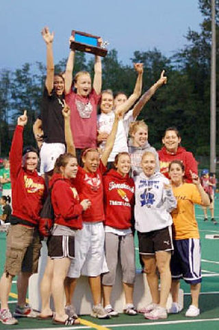 Senior Nicolette Runyan hoists the award plaque as the M-P girls team celebrates its first district championship since 1976.